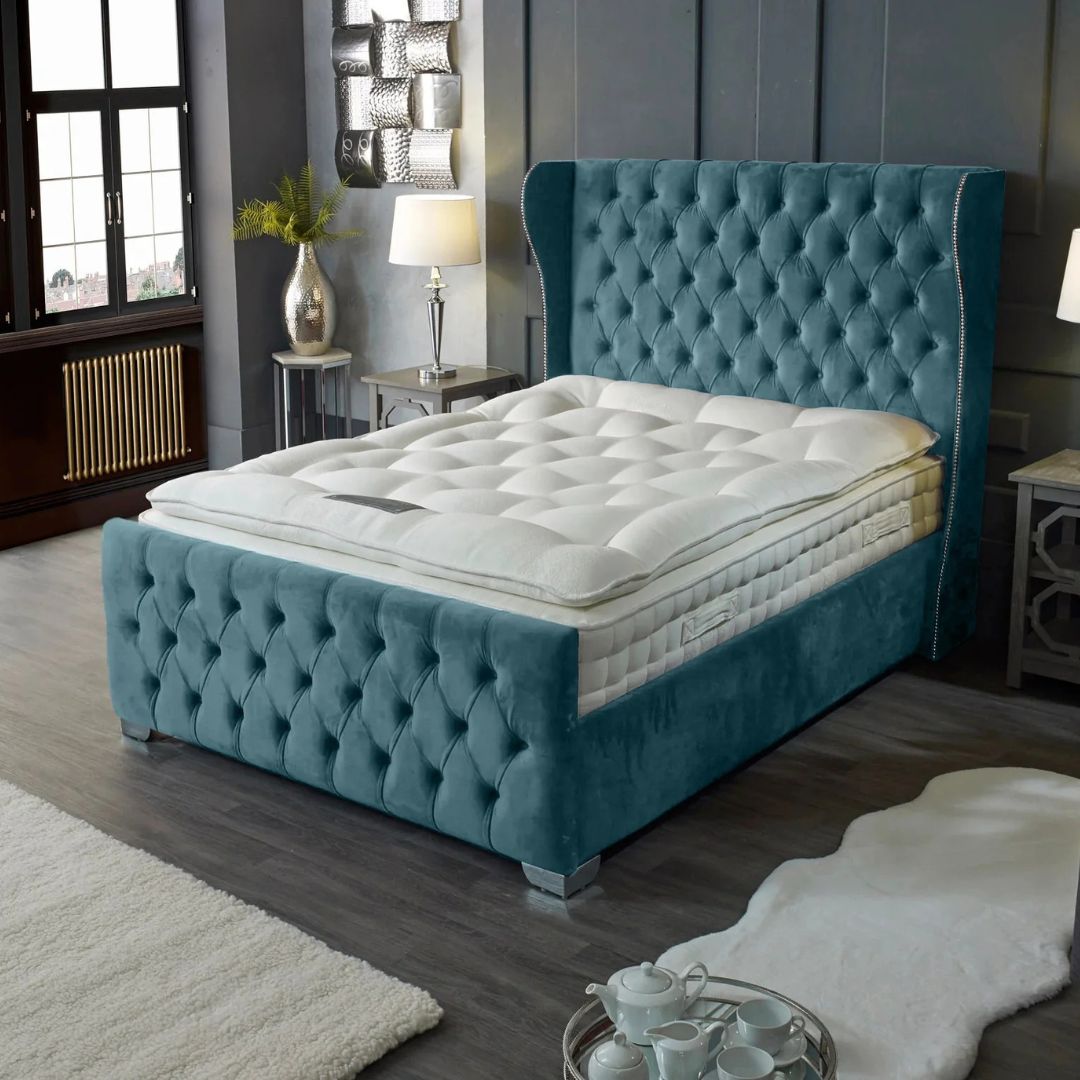 Teal tufted bed with white mattress in a bedroom setting